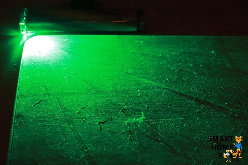 Green laser on hard floor in the dark